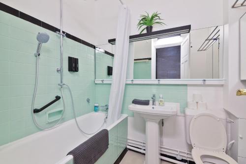 une salle de bain avec une douche, des toilettes et un lavabo dans l'établissement Élégant Studio Appartement Quartier Les Marais Free Netflix, à Paris