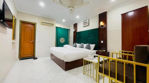 a hotel room with a bed and a table at Hotel New Mid City Multan in Multan
