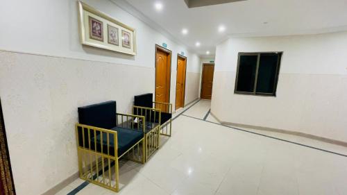 a hallway with two chairs in a room at Hotel New Mid City Multan in Multan