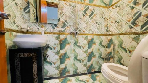 a bathroom with a sink and a toilet at Hotel New Mid City Multan in Multan