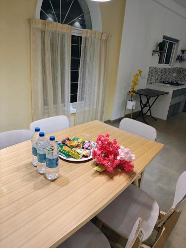 a wooden table with a plate of food and water bottles at Boom Party Villa in Pirangut