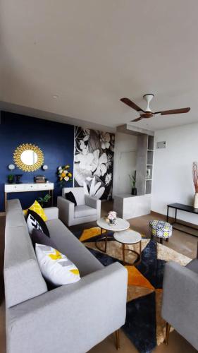 a living room with couches and tables and a ceiling at Boom Party Villa in Pirangut