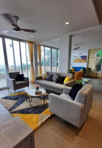 a living room with two couches and a table at Boom Party Villa in Pirangut