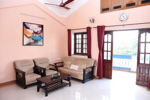 a living room with two chairs and a table at Casa Maroquinha, 3bed Dona Paula in Panaji