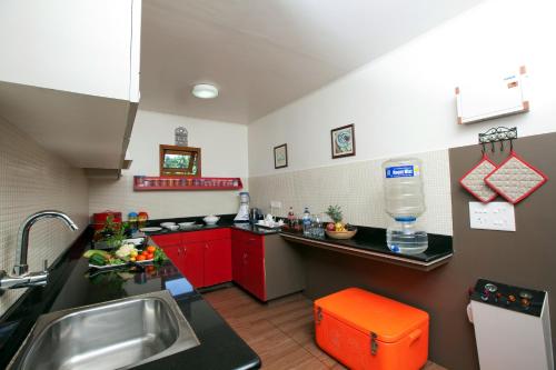a small kitchen with red cabinets and a sink at Abad Premium House Boat in Kumarakom