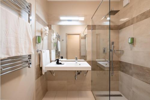 a bathroom with a sink and a shower at Silver Crown Hotel & Residence, Palace Quarter in Budapest