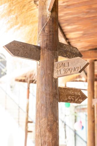 a wooden sign on a wooden pole at Le Petit Palais Djerba & Spa in Houmt Souk