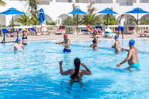a group of people playing in a swimming pool at Le Petit Palais Djerba & Spa in Houmt Souk