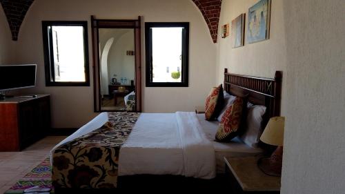 a bedroom with a large bed and a mirror at Beach safari nubian resort in Marsa Alam City