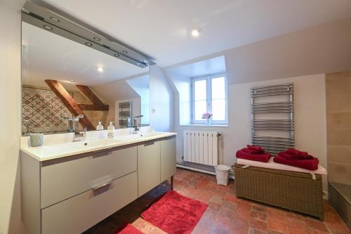 a bathroom with a white sink and a red rug at Château Les Arcis in Hauterive