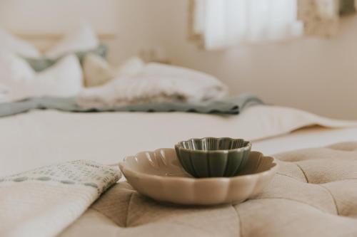 a bowl sitting on top of a bed with a bowlasteryasteryasteryasteryastery at Neidhardt Vendégház in Bóly
