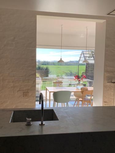 a kitchen with a sink and a view of a table at Logieslogees in Tielrode