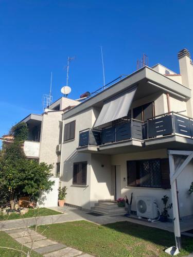 a white building with blue balconies on it at LA MAISON aeroporto ciampino in Ciampino