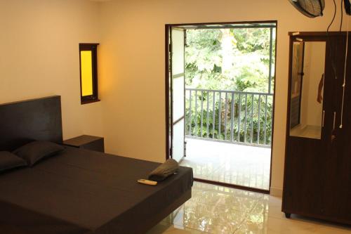 a bedroom with a bed and a sliding glass door at Greens Homestay Varkala in Varkala