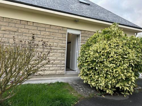 a house with two large hedges in front of it at Appart F2 spacieux proche Paris in Chambly