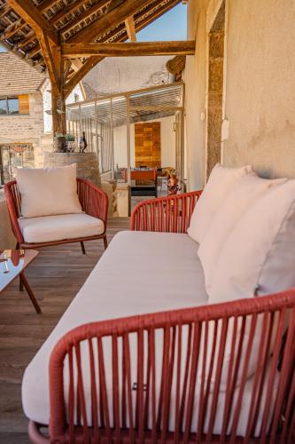 - un lit et une chaise sur une terrasse couverte dans l'établissement Gîte des Cadoles, à Saint-Jean-de-Vaux