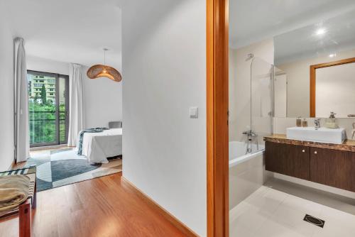 ein Badezimmer mit Badewanne und Waschbecken und ein Bett in der Unterkunft Relax Stay in Funchal