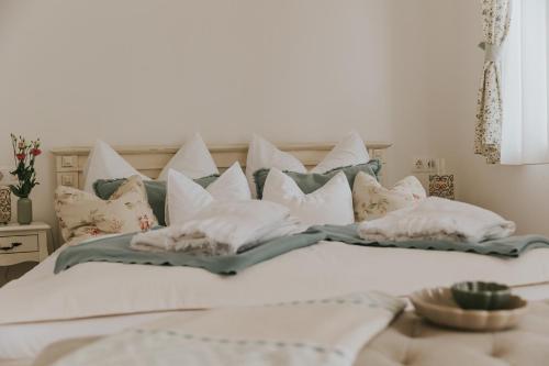 a bedroom with a white bed with pillows at Neidhardt Vendégház in Bóly