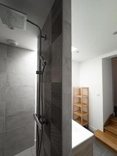 une douche avec une porte vitrée dans une salle de bain dans l'établissement Gîte des Cadoles, à Saint-Jean-de-Vaux