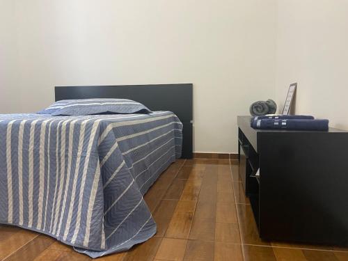 a bedroom with a bed and a dresser at Confortável Apartamento in Pouso Alegre