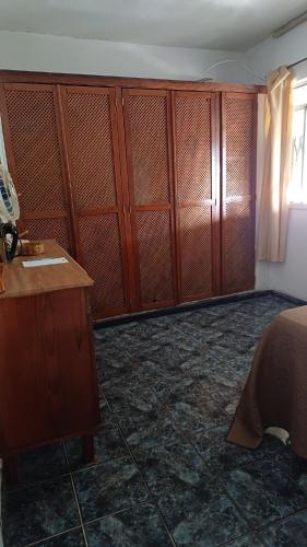 a bedroom with wooden cabinets and a bed and a window at Cantinho dos Barbosas in Angra dos Reis