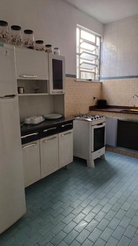a kitchen with white cabinets and a stove at Cantinho dos Barbosas in Angra dos Reis
