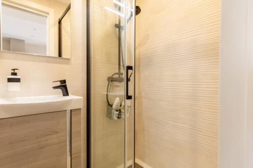 łazienka z drzwiami prysznicowymi i umywalką w obiekcie Duplex With Sunny Terrace Located In Mijas Pueblo w mieście Mijas