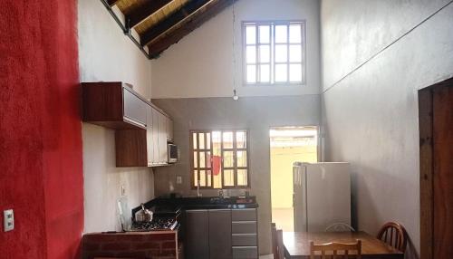 a small kitchen with a table and a refrigerator at Casa da família Castro in Capão da Canoa