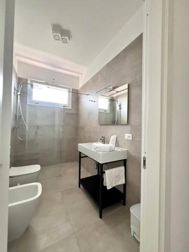 a bathroom with a sink and a tub and a toilet at ADAGIO by Verde Blu Vacanze in Porto Cesareo