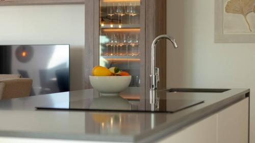 a kitchen with a bowl of fruit on a counter at Stylish Central Apartment & Panoramic Views Mijas in Mijas
