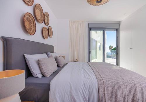 a bedroom with a large bed and a window at Luxury New Boho Style Apartment In Mijas Pueblo! in Mijas