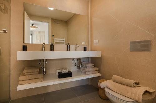 a bathroom with a sink and a mirror and a toilet at Luxury New Boho Style Apartment In Mijas Pueblo! in Mijas