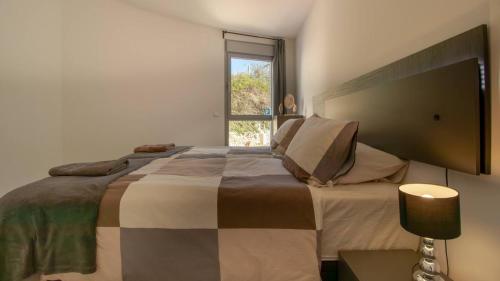 a bedroom with a large bed and a window at Stylish Central Apartment & Panoramic Views Mijas in Mijas
