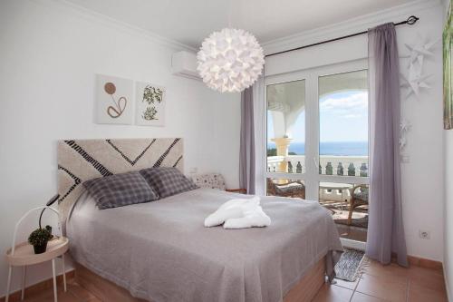 een slaapkamer met een bed met uitzicht op de oceaan bij Cozy townhouse Mijas with views in Mijas