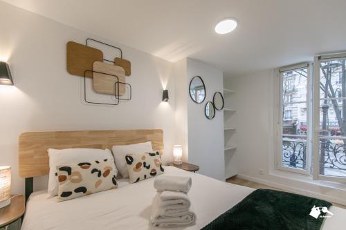 - une chambre avec un lit doté de draps blancs et d'oreillers en vache dans l'établissement MBA - Splendide Appart Proche Père Lachaise, à Paris