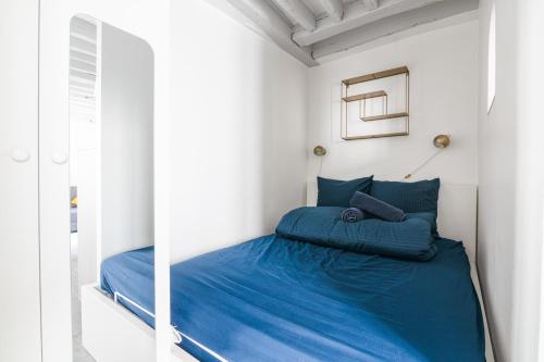 une chambre avec un lit avec une couette bleue dans l'établissement Élégant Studio Appartement Quartier Ile Saint Louis Free Netflix, à Paris