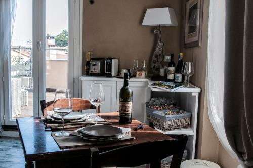 a dining room table with a bottle of wine and glasses at Zia Letizia Bed And Wine in Monterosso al Mare