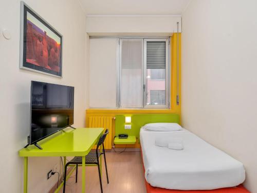 a room with a bed and a table and a desk at B&B HOTEL Milano Ornato in Milan