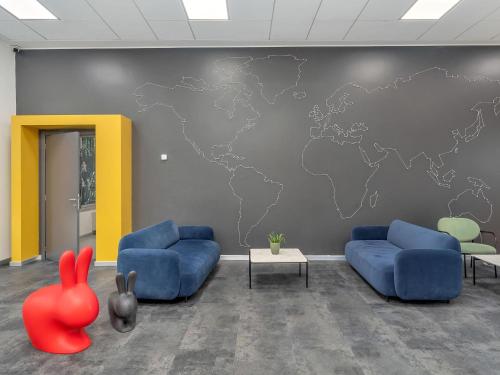 a waiting room with a map of the world on a wall at B&B HOTEL Milano Ornato in Milan