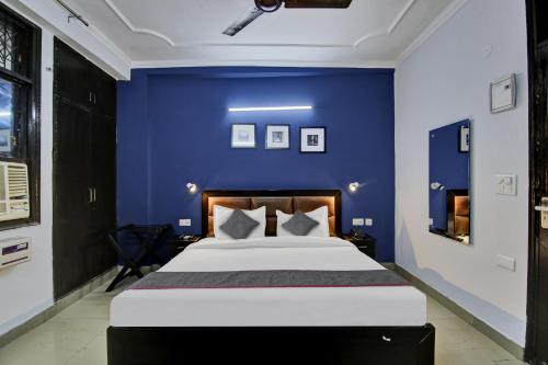 a bedroom with a blue wall and a bed at Townhouse Saket Residency Near Saket Metro in New Delhi