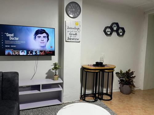 a living room with a flat screen tv on a wall at Pequeno Cielo staycation in Nairobi
