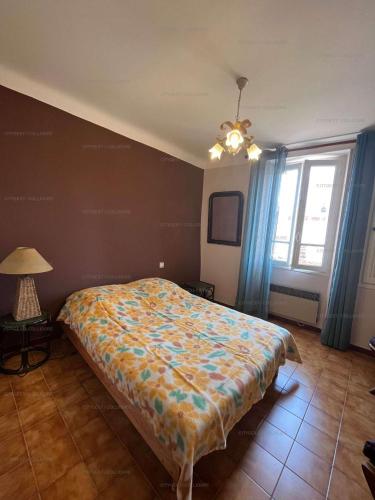 une chambre avec un lit, une lampe et une fenêtre dans l'établissement 3FAN4-Charmant appartement-Vue sur la mer et clocher de Collioure, à Collioure