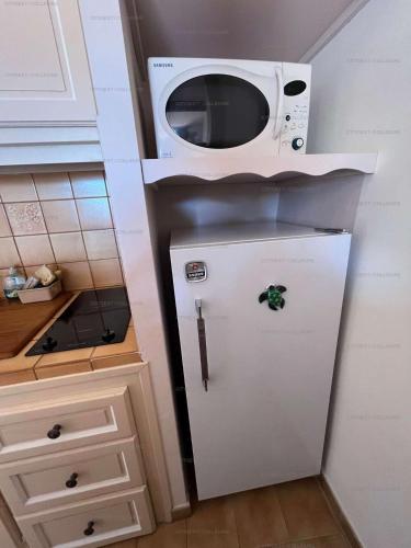 un micro-ondes au-dessus d'un réfrigérateur dans une cuisine dans l'établissement 3FAN4-Charmant appartement-Vue sur la mer et clocher de Collioure, à Collioure