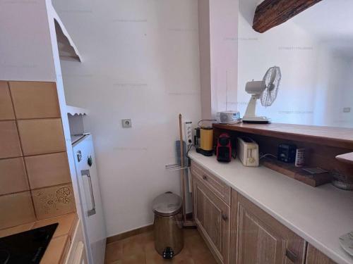 - une cuisine avec un comptoir et un ventilateur dans l'établissement 3FAN4-Charmant appartement-Vue sur la mer et clocher de Collioure, à Collioure