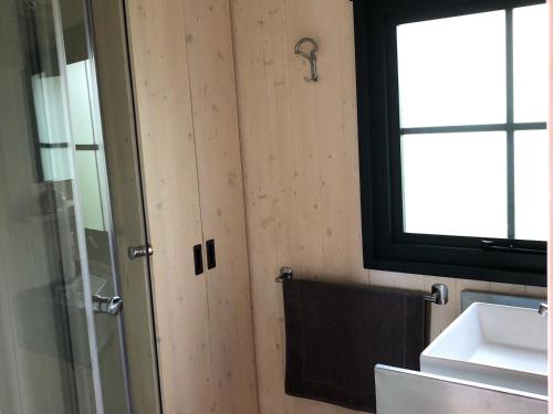 a bathroom with a shower and a sink and a window at Les Lodges de Phanou in Prissac