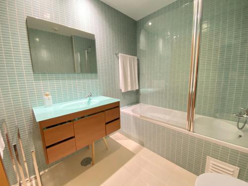 a bathroom with a sink and a tub and a mirror at Am Hafen - House Barbara 1 l Marina Olhão in Olhão
