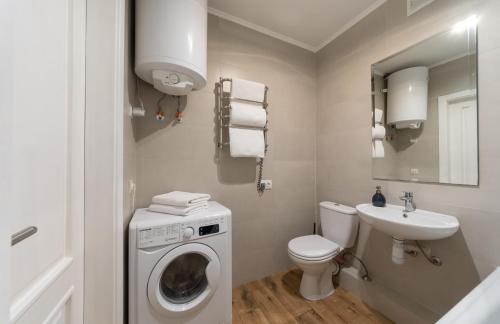 a bathroom with a washing machine and a sink at N.A.N Apartments on Krushelnytska in Kyiv