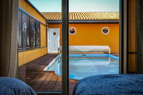 une vue d'une piscine à travers une fenêtre dans l'établissement Superbe villa avec piscine située à 2 km de la Grande Plage des Sables, à Les Sables-dʼOlonne