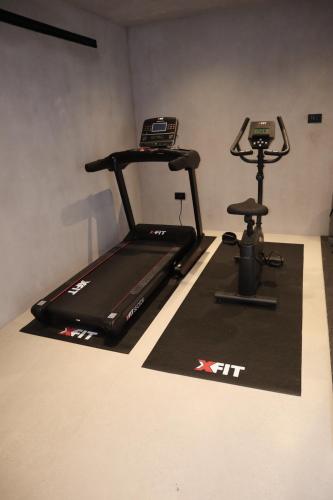 a gym with a treadmill and a exercise bike at Lithos Art Villas in Sarlata
