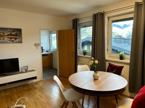 a living room with a table and chairs and a television at Seeblick 11 in Zell am See
